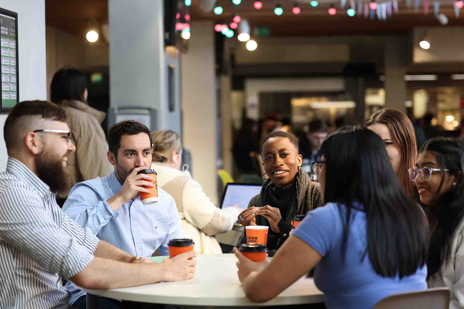 Group of students drinking coffee and having a chat.