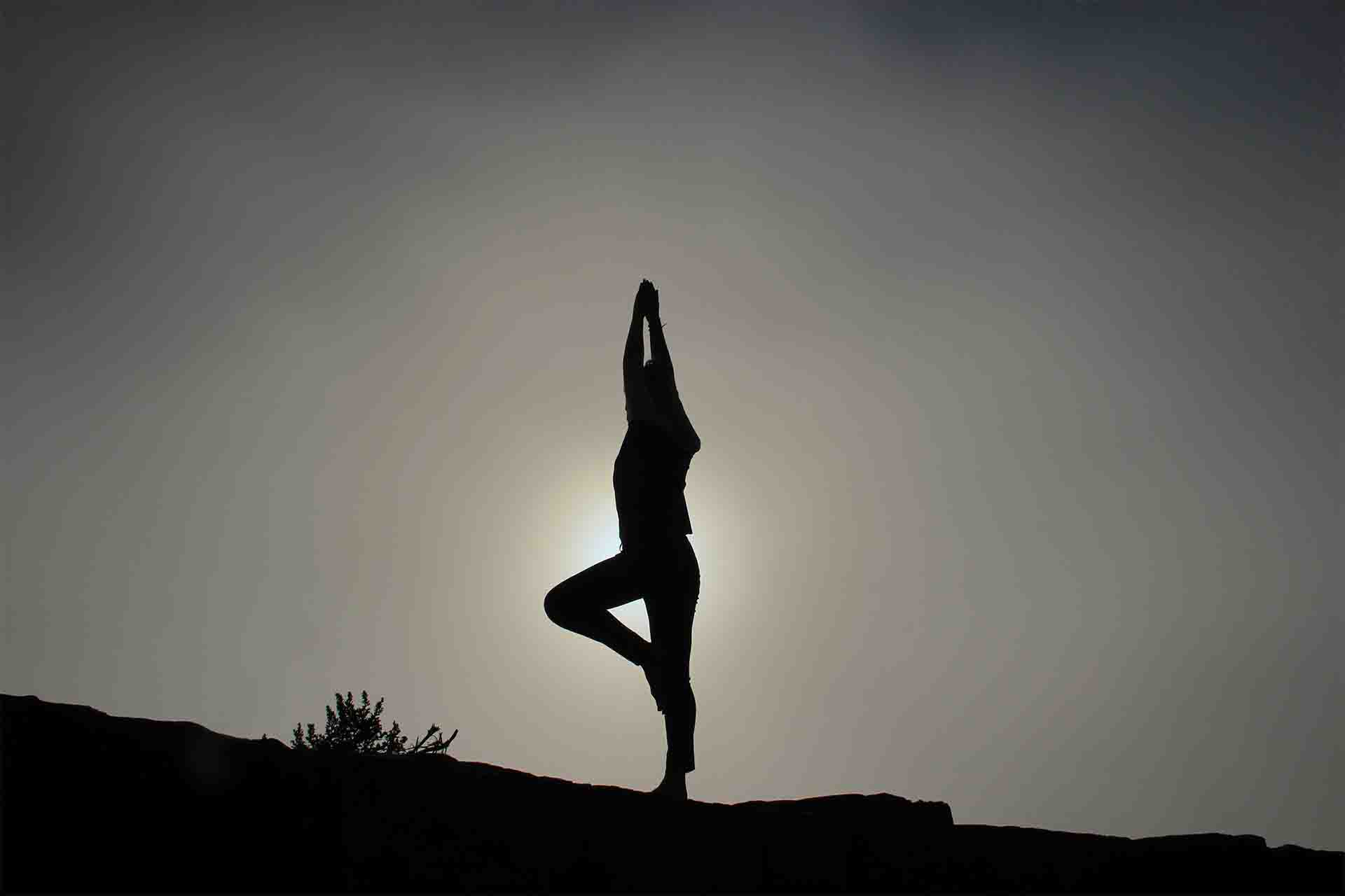 A person doing yoga at sunset