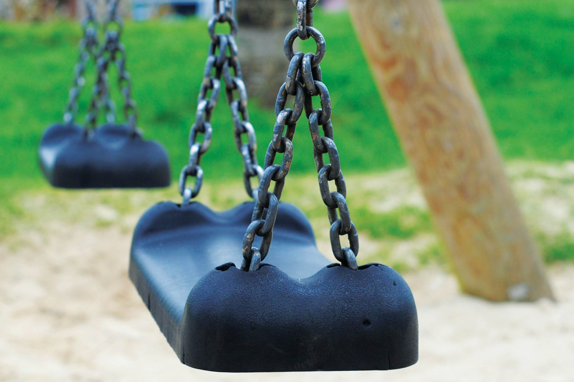 Empty swinging swing in the playground.