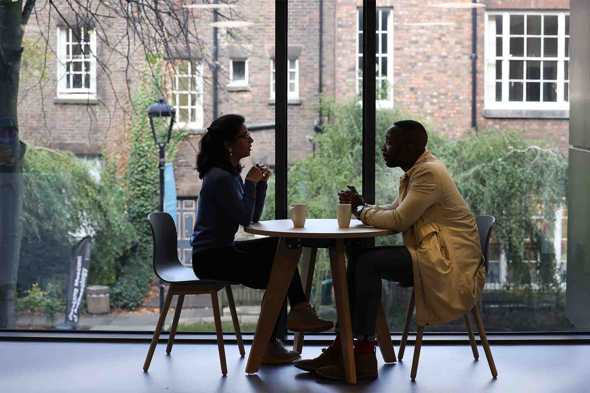 Two researchers sat at a table having a discussion.