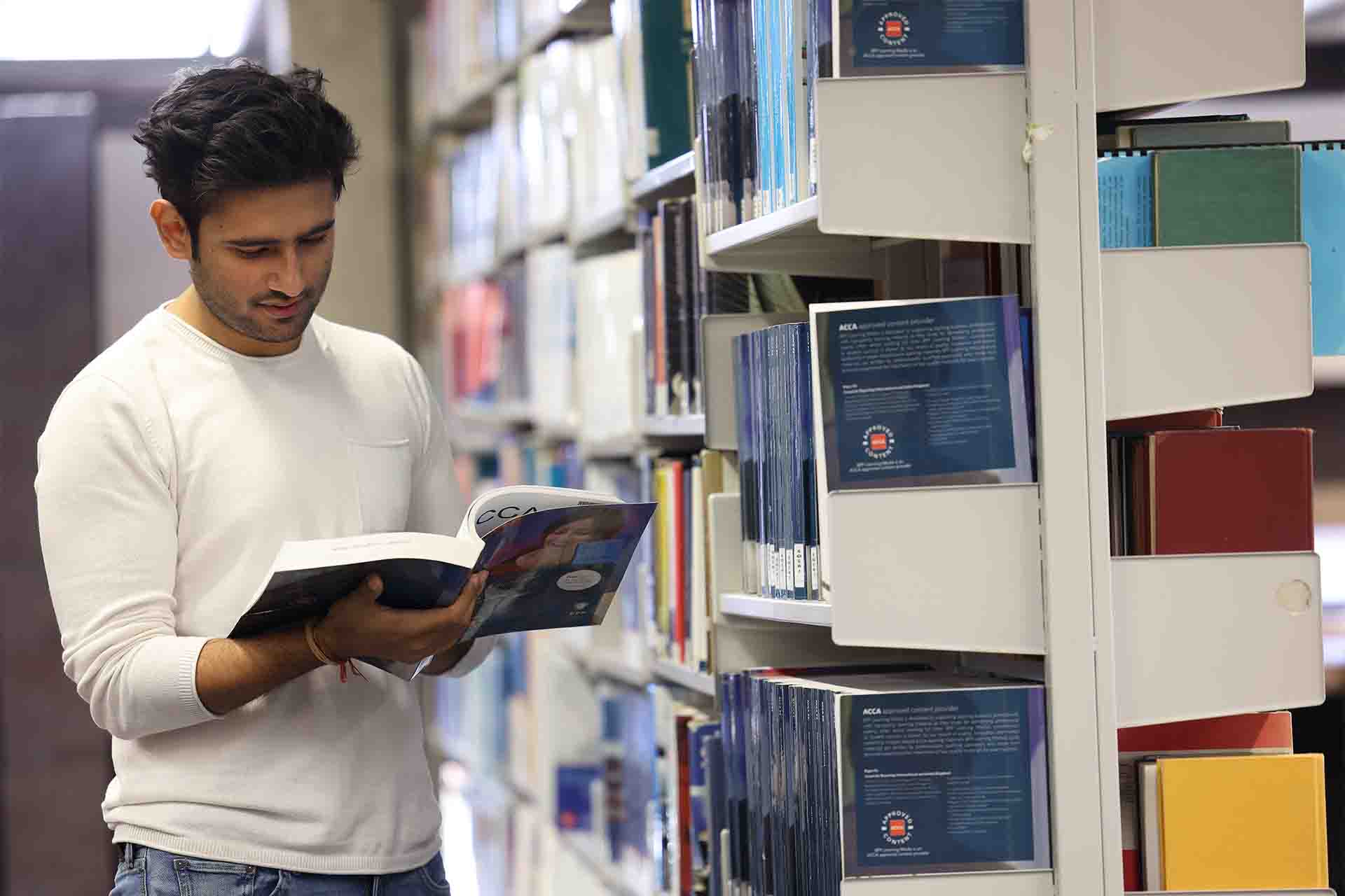 A student reading a book in the library.