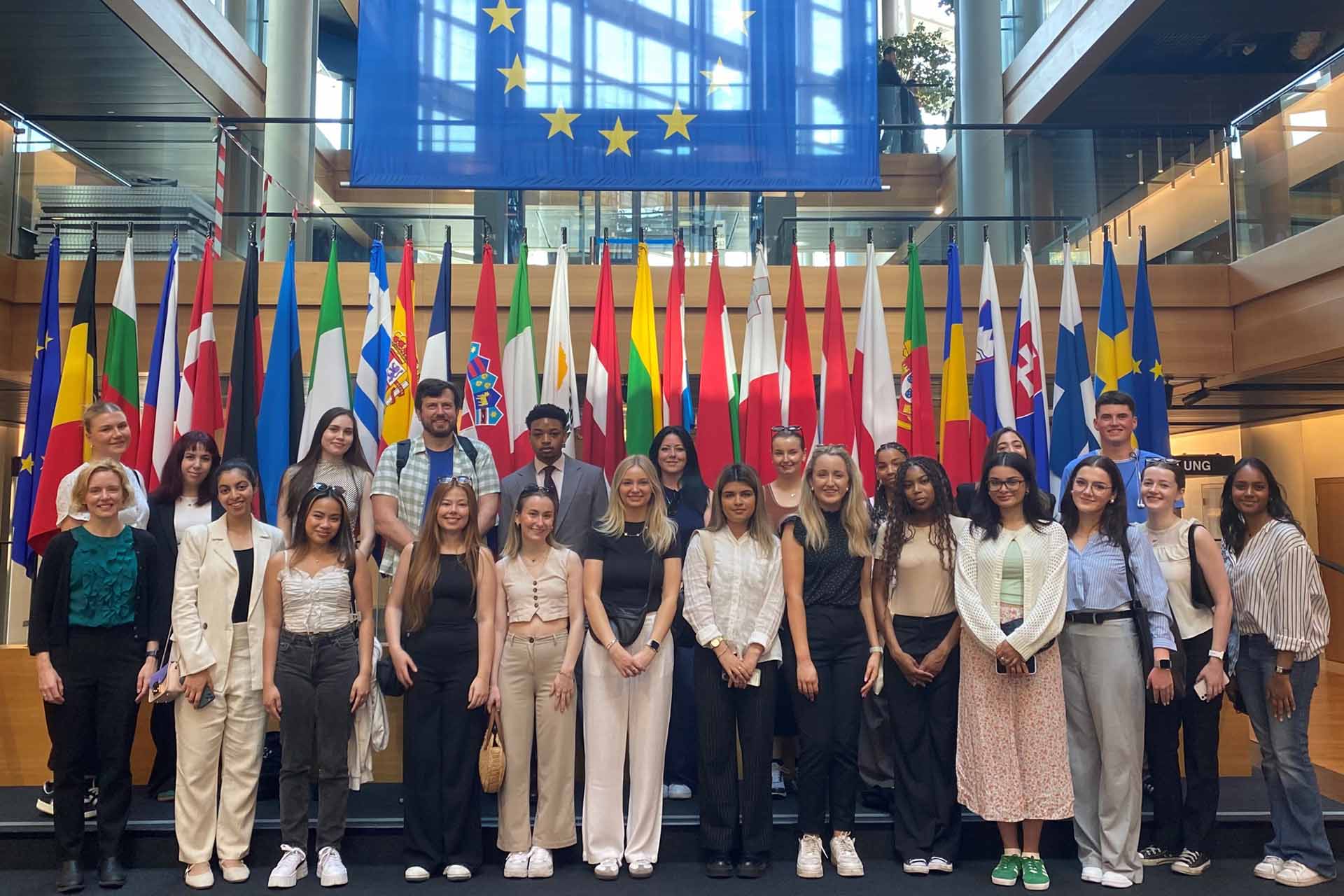 The group of students stood in front of EU flags.