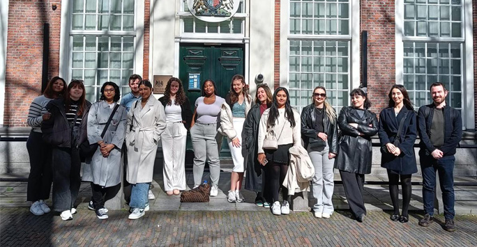 A group of students stand together outside of the British Embassy of The Hague.
