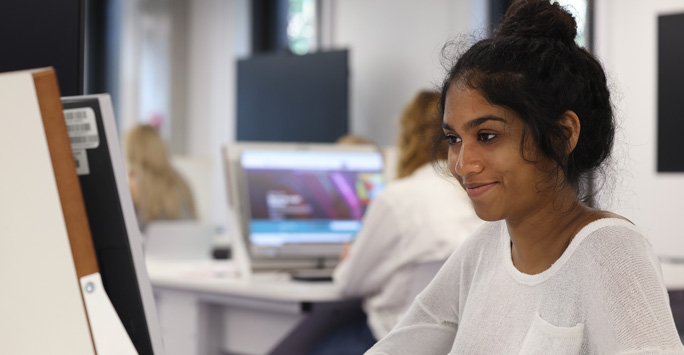 A student sat at a computer desk.