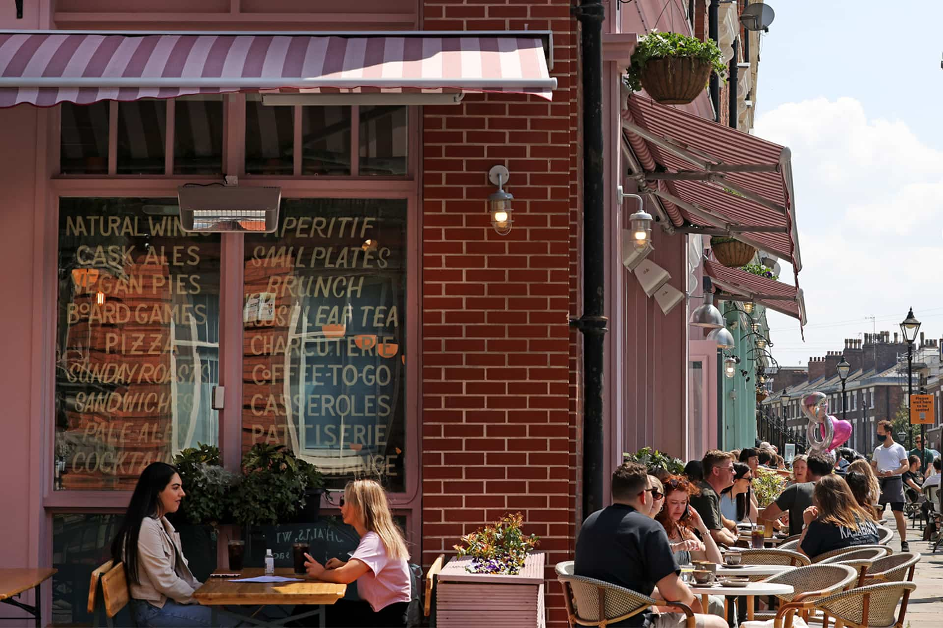 Outdoor café with people sitting at tables on a sunny day.