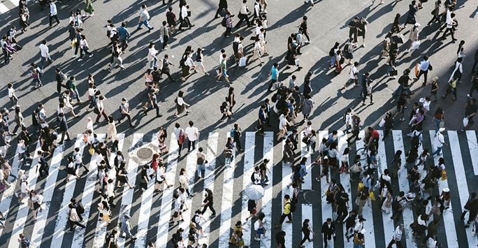 People walking across a zebra crossing.