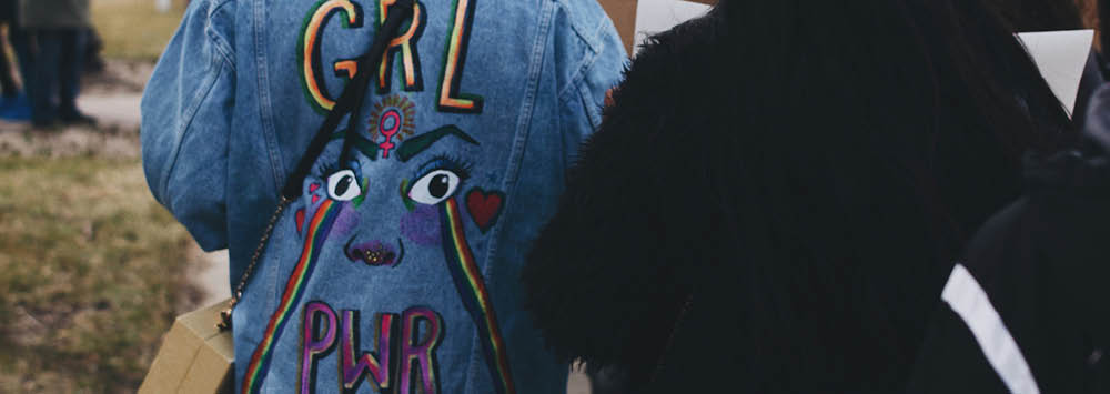 A denim jacket with design that reads 'Grl Pwr'