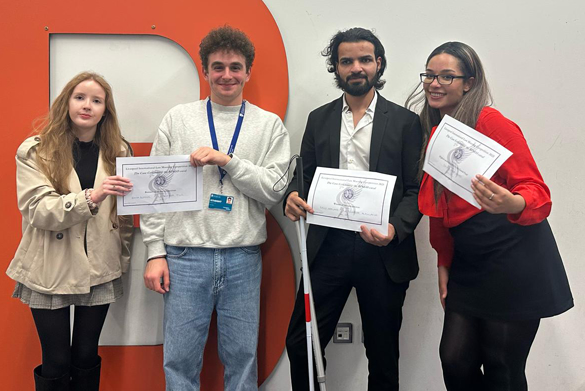 Four students standing together holding certificates.