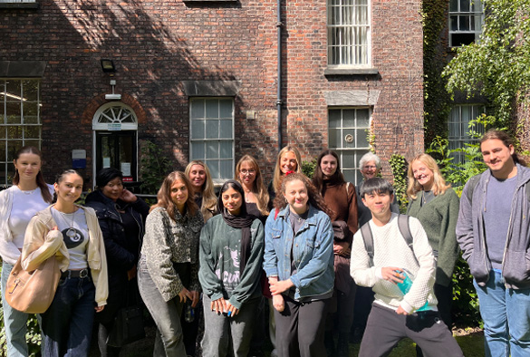 A group of Law Clinic students stand in front of a building.