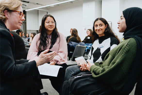 A group of students sit together in conversation with a visiting Judge.