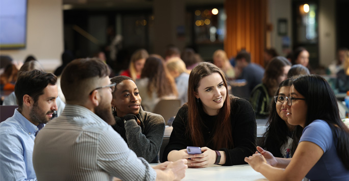 A group of students sit around a table.