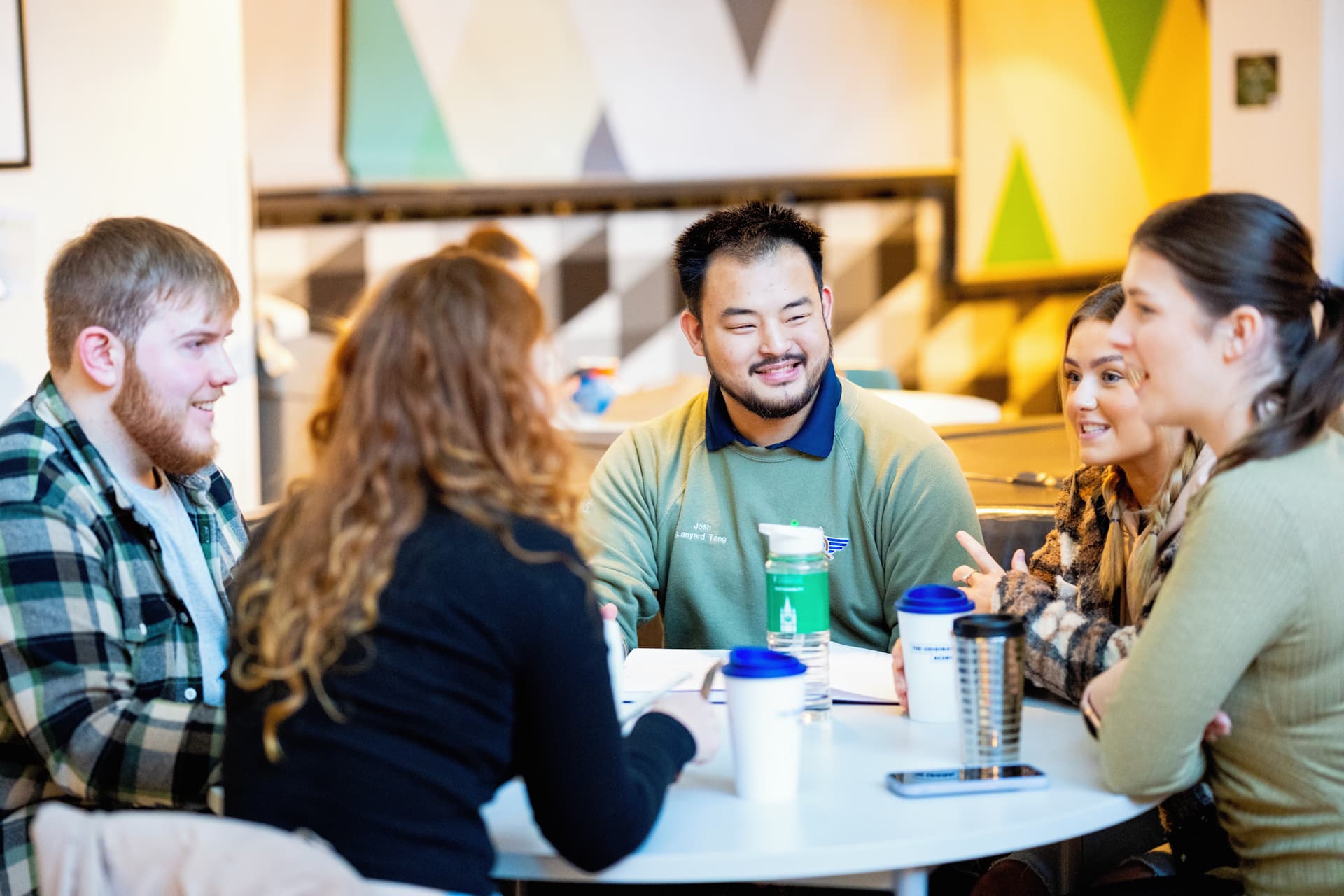 A group of students chatting at a table in the Guild