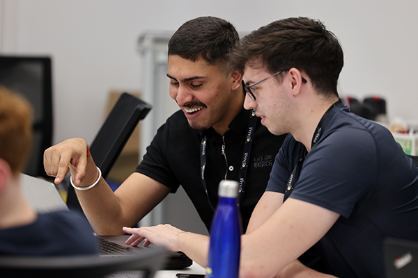 Two students in front of a laptop.