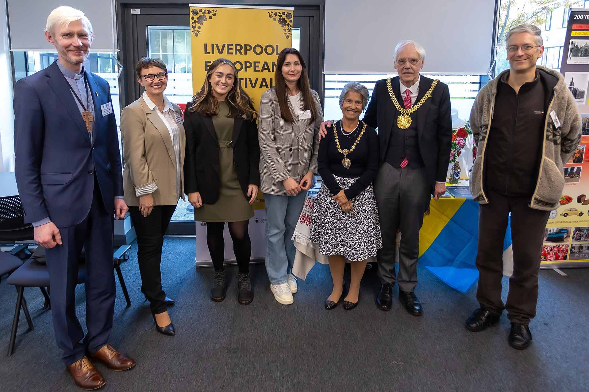 Group picture of attendees of the event smiling and standing together with the Mayor of Liverpool