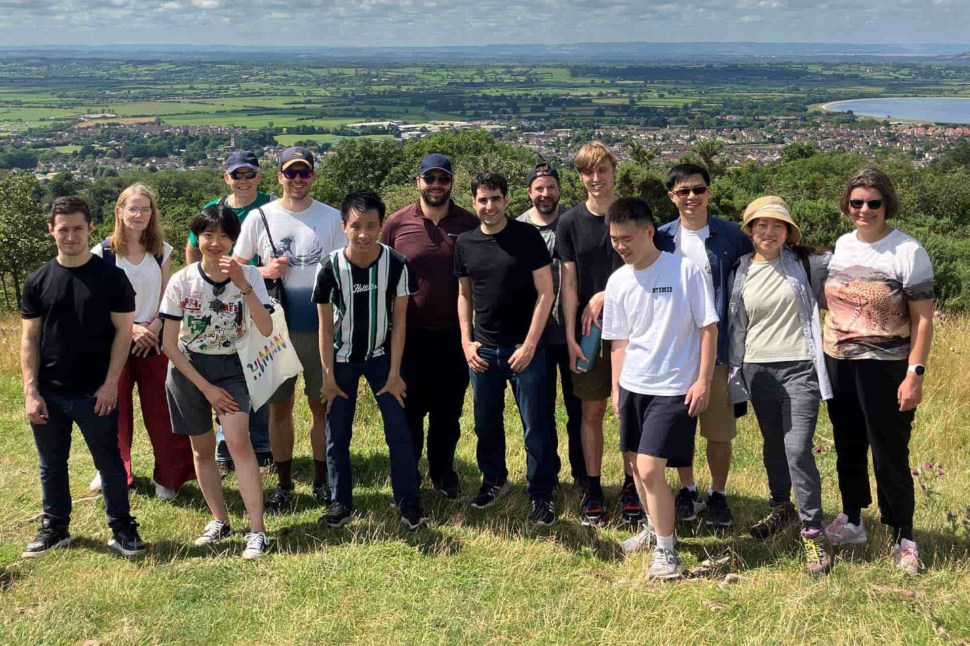 A group of students standing together on top of a grassy hill in the countryside