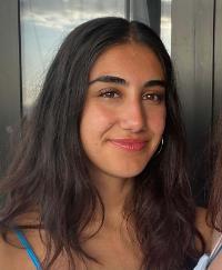 A headshot of female student with dark hair smiling