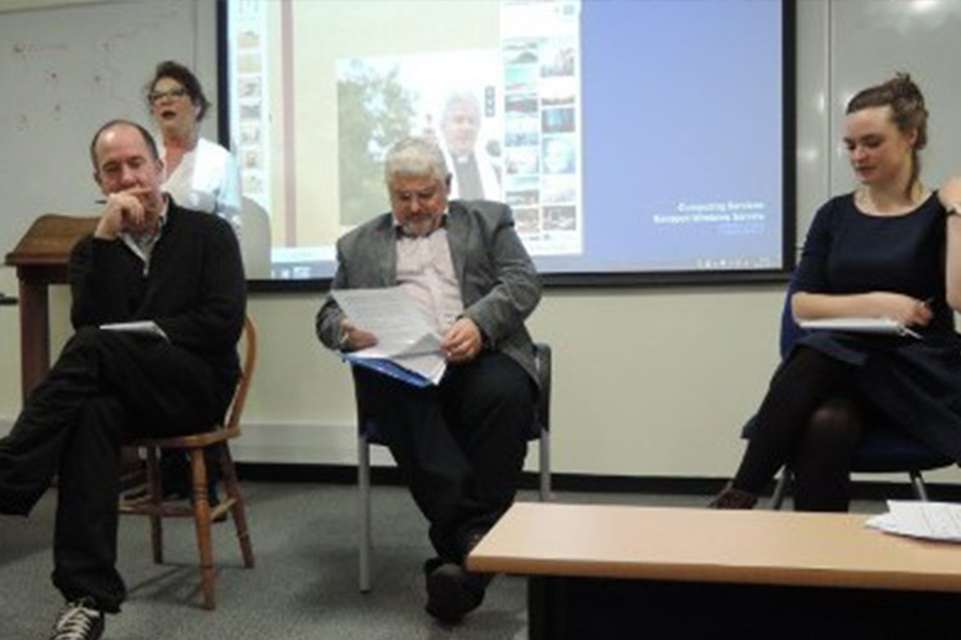 Three people presenting and discussing at an event