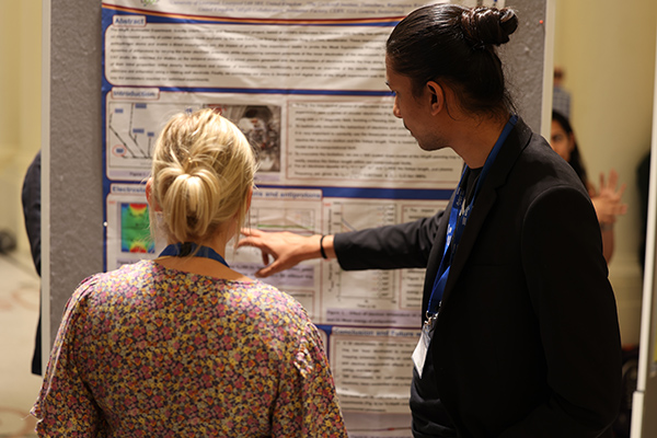 A person explaining something at a poster session.