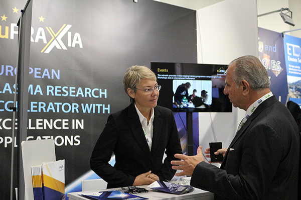 Two people talking at an industry booth.