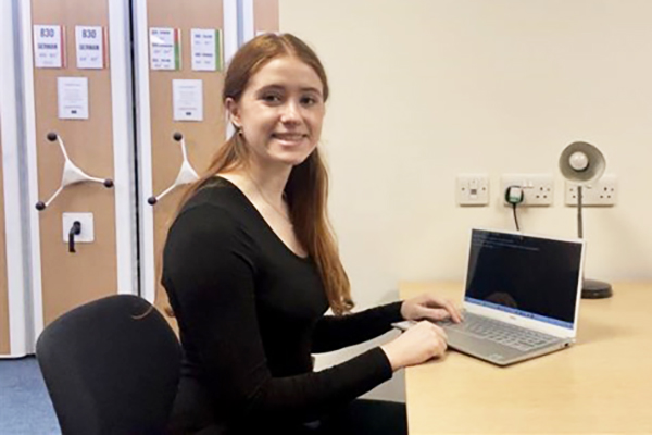 A person sitting at a desk posing for a photo.