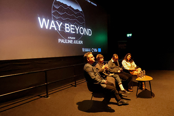 Panel members in front of a screen.