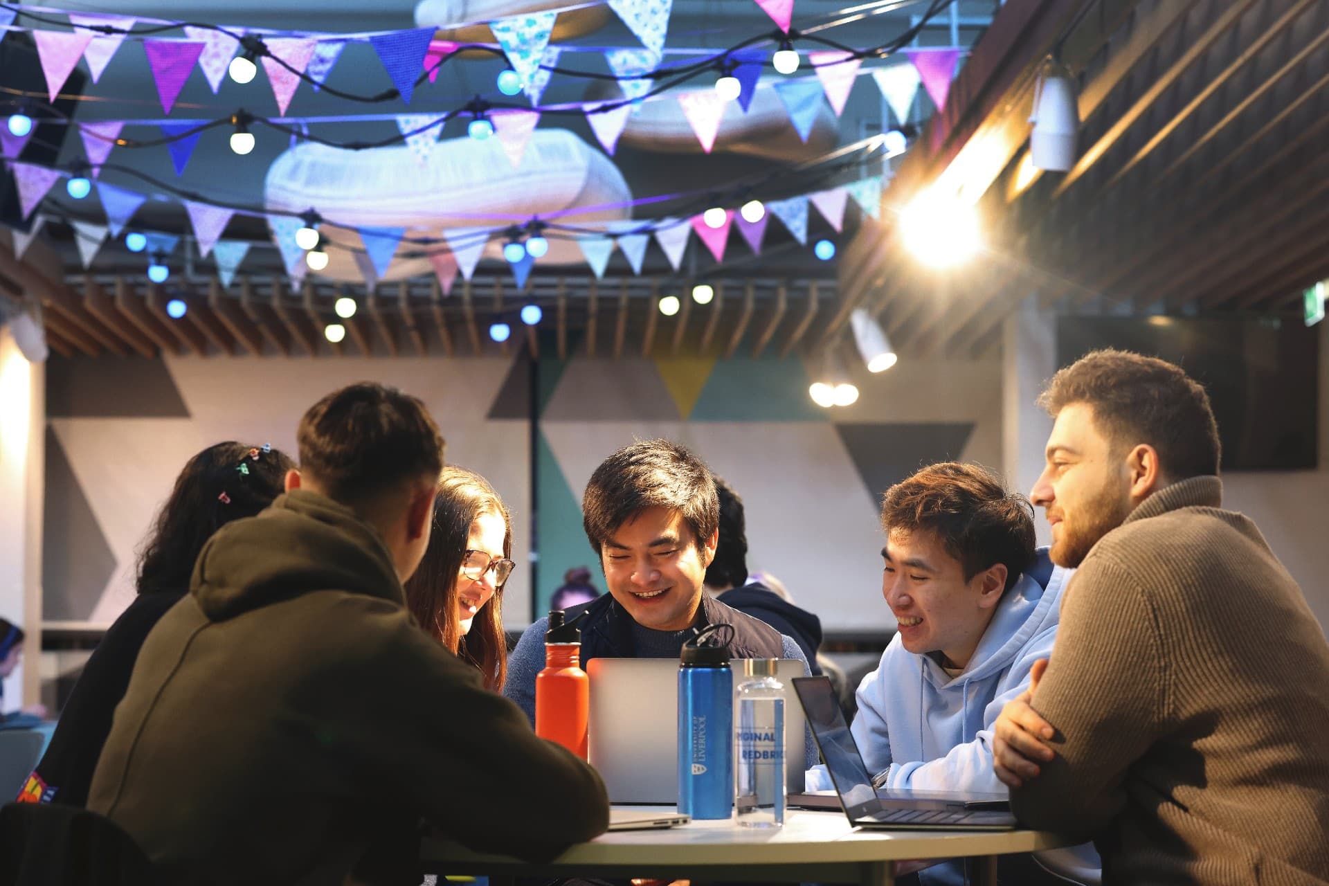 A group of students sitting around a table, laughing.