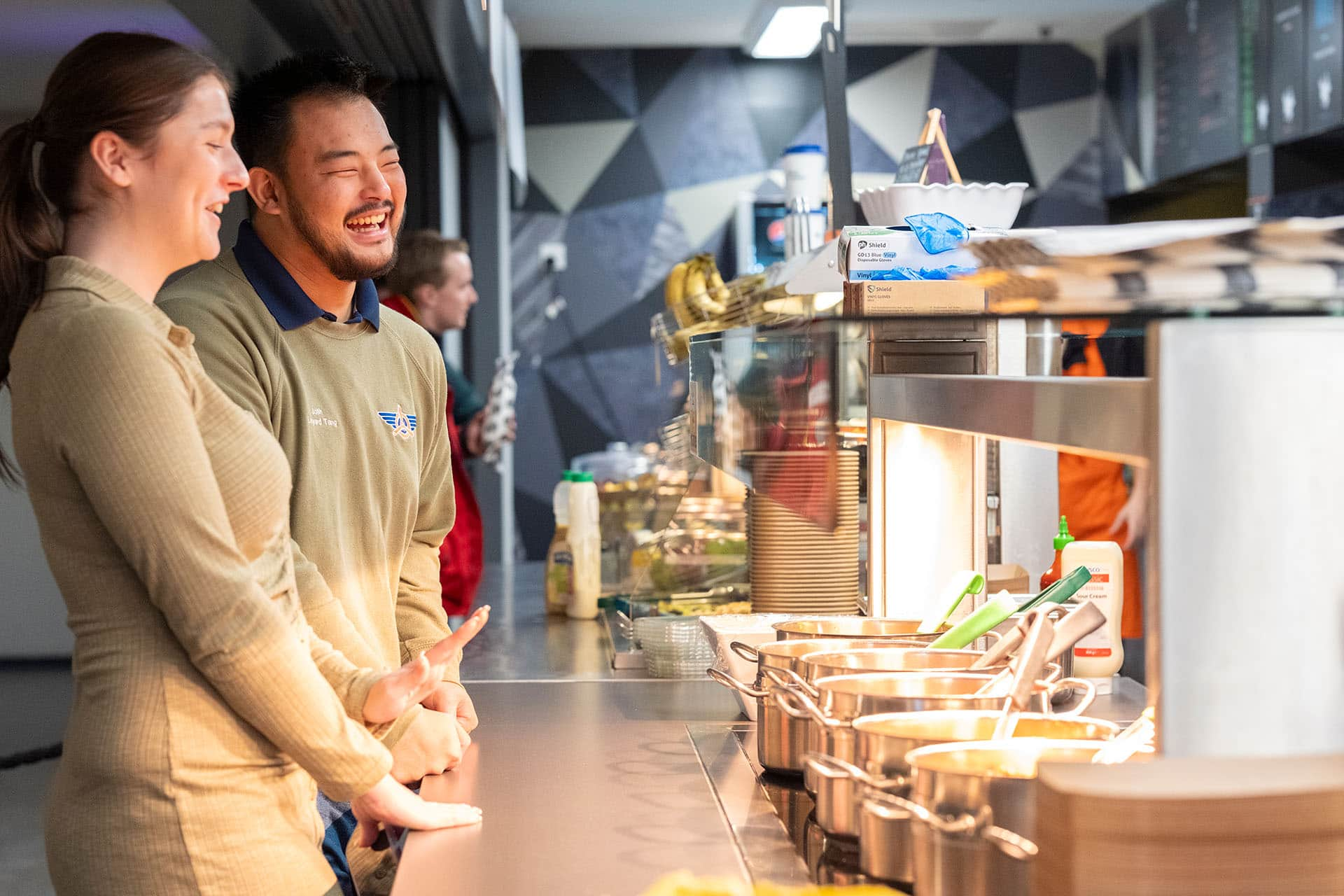 Two students ordering food at the counter in the Guild of Students