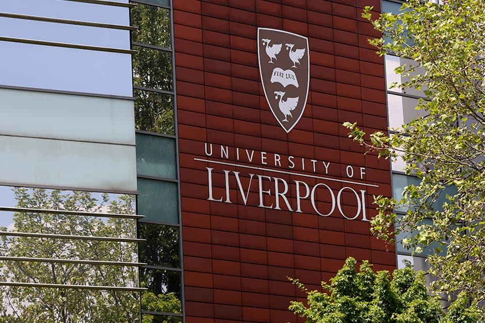 Building on campus with glass windows and University logo on the exterior