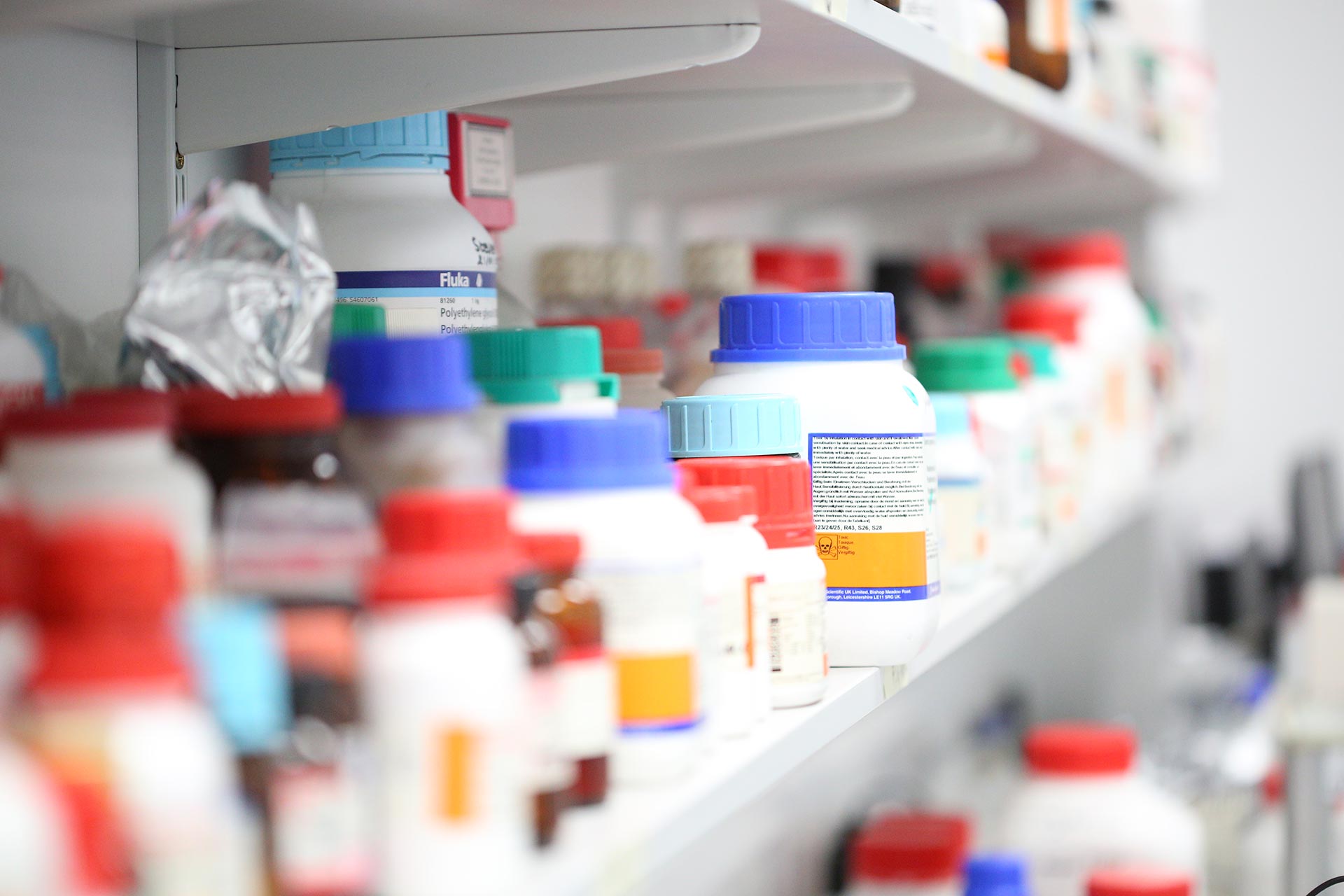 Photograph showing lots of medicine containers on a shelf in a lab