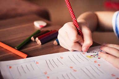 Child's hand writing on paper