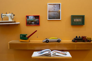 Toys on shelves against a yellow wall