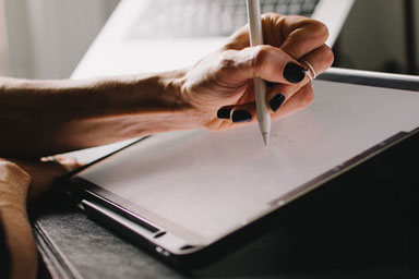 Hands writing on a tablet