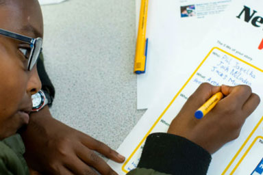 A boy writing in a workbook