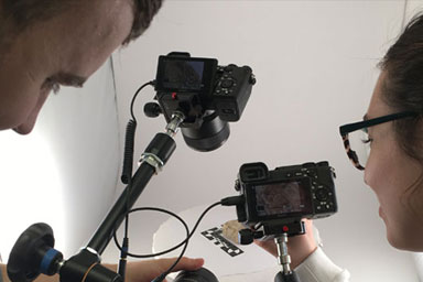 Two students photographing an object