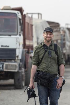 Richard Stupar walking towards the camera with lorries in the background