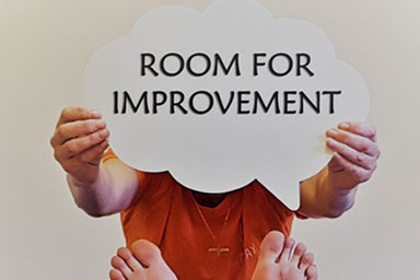 Someone holding a 'Room for Improvement' sign