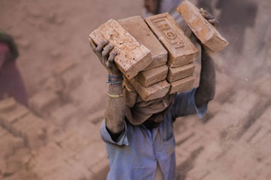 A man carrying bricks on his head