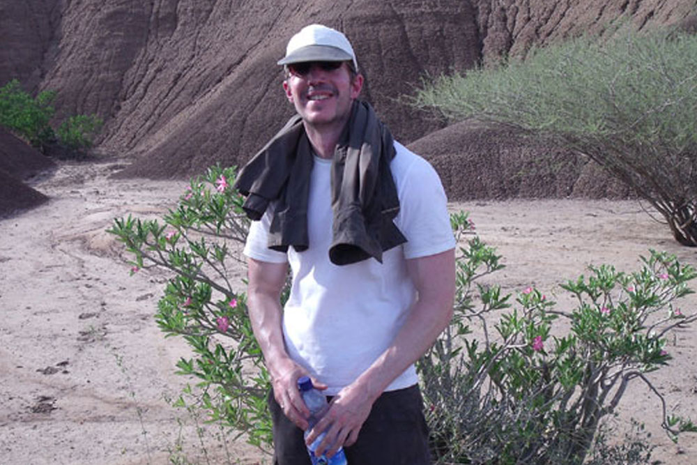 A researcher in a rocky desert landscape