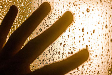 A hand against a rainy window