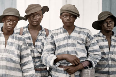 Early 20thC photo of four young Black men in prison uniforms