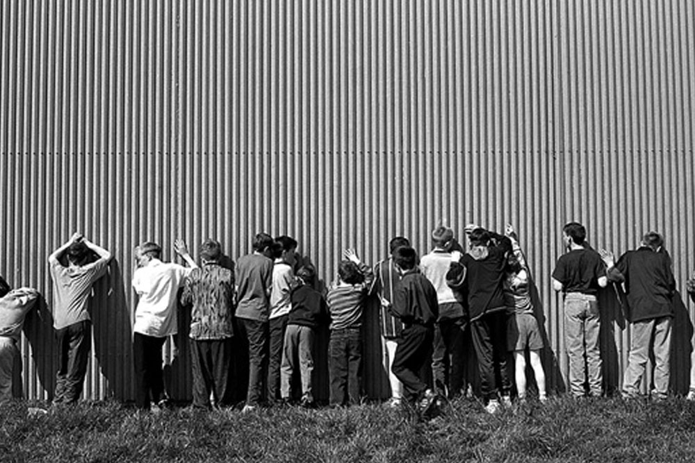 B&W photo of children standing against a wall