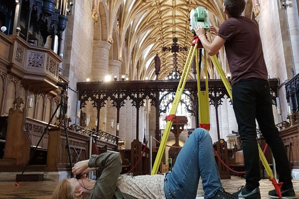 Researchers in an old church photographing the ceiling