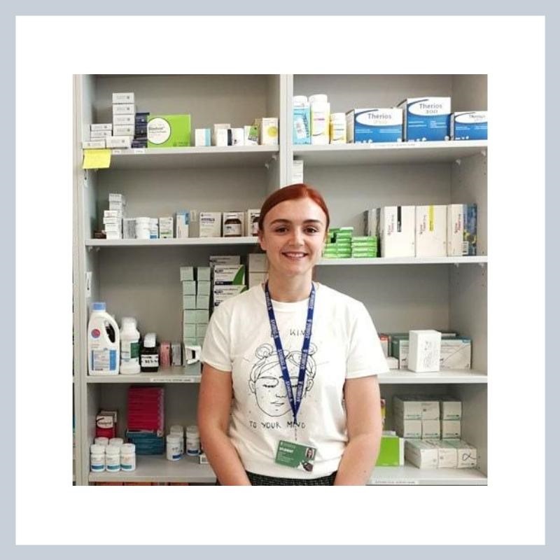 female smiling at camera in pharmacy