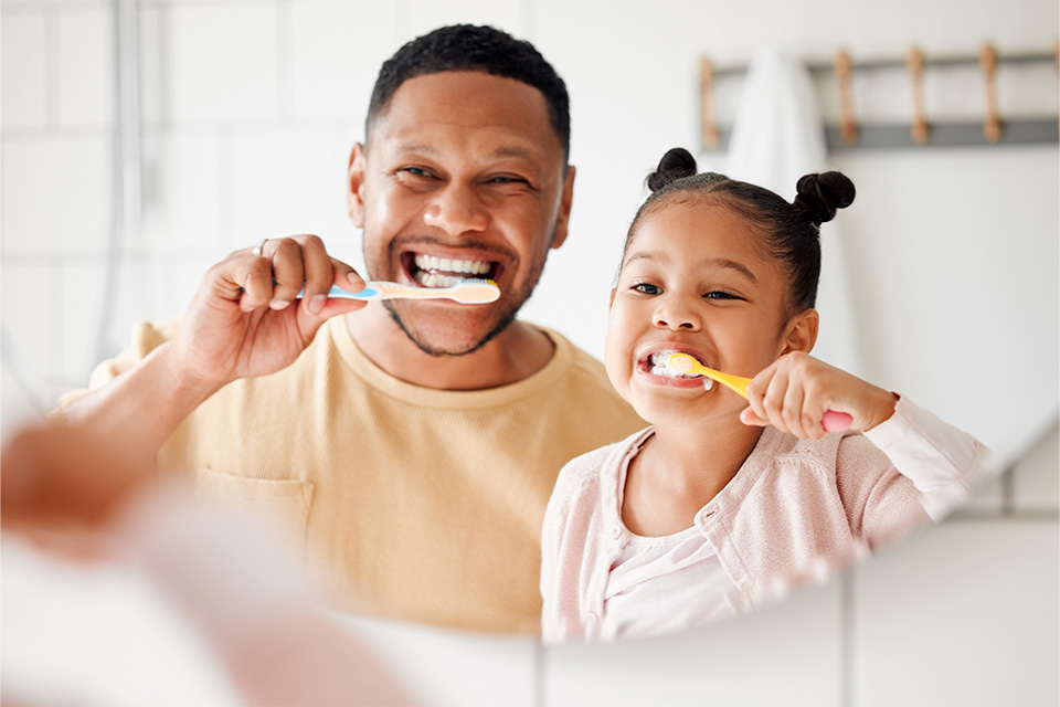 parent and child brushing teeth