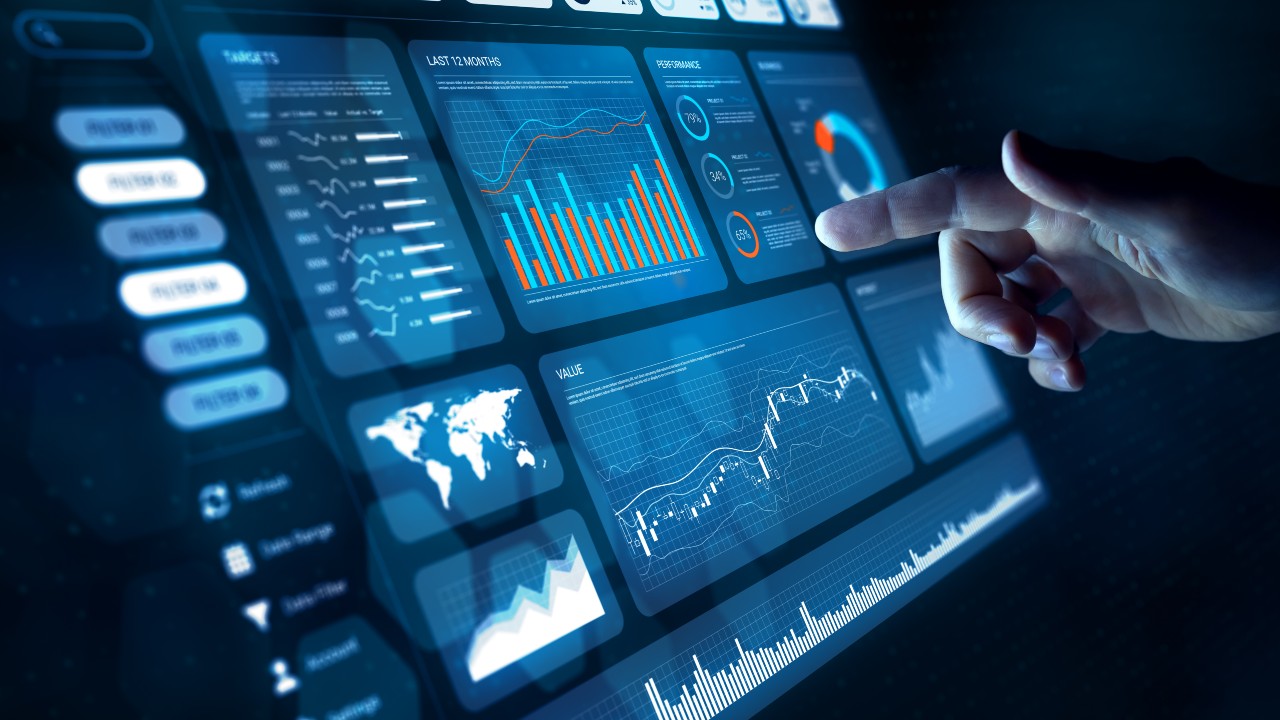 Hand pointing to various digital graphs