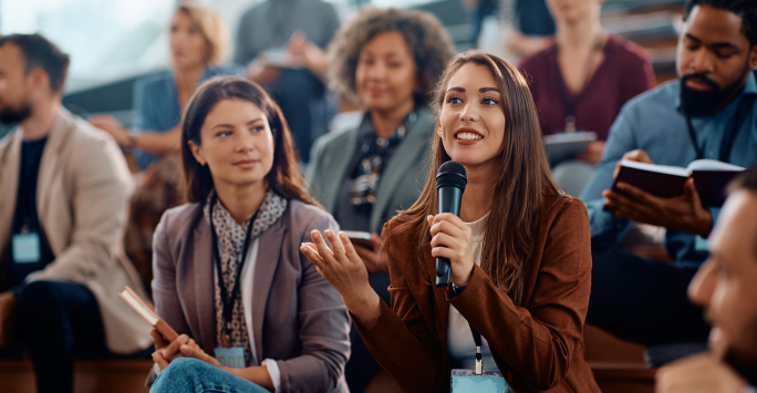 Member of the audience asking questions at professional development workshop (PDW)