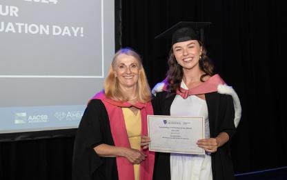 Hannah Kirtley receiving award at graduation from Dean of the School