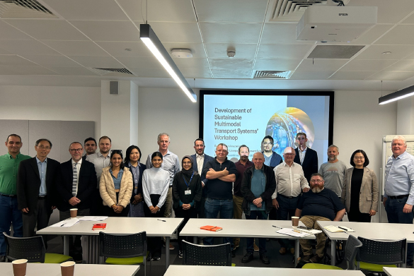 Delegates standing posing for a photograph in front of presentation screen