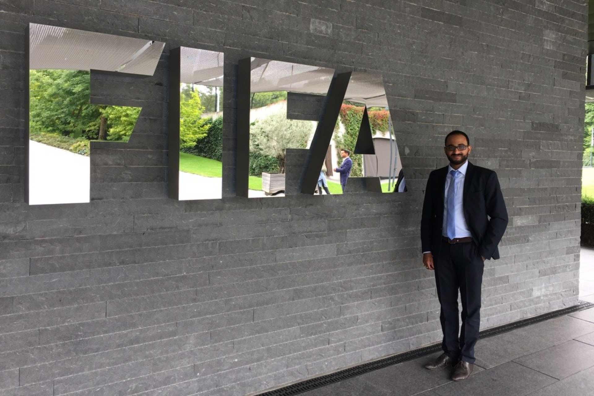 Shah student posing next to FIFA sign during a field trip.