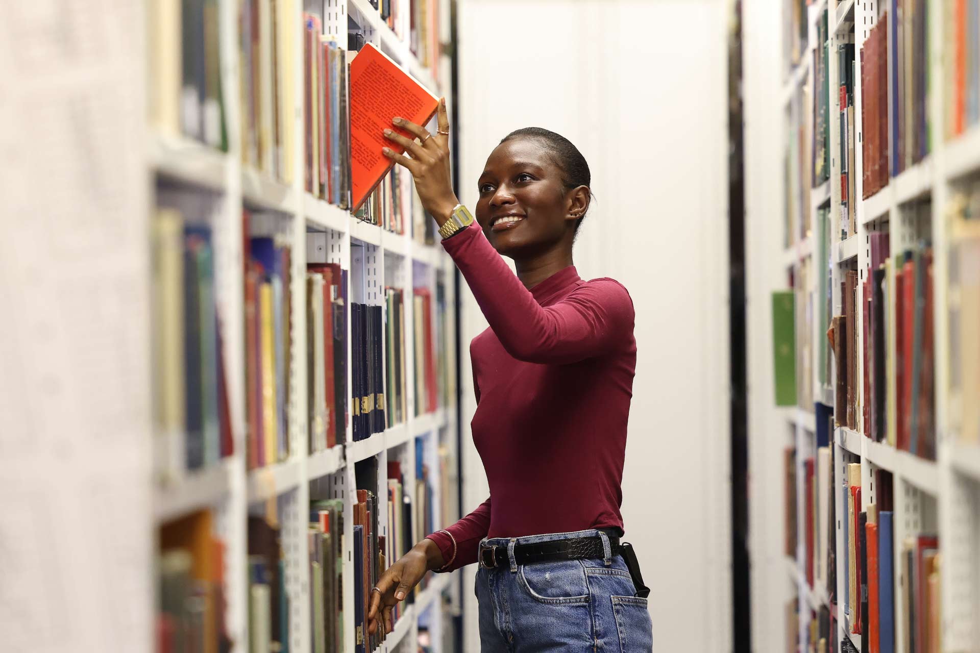 Female student searching for a book at the library